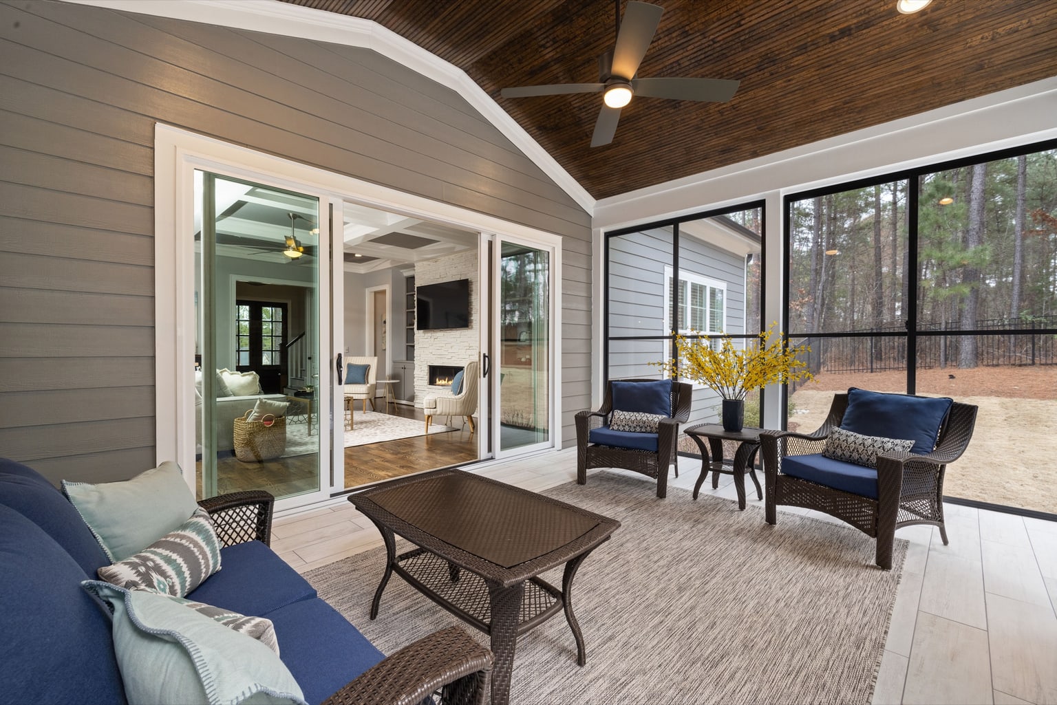 Screened room with a vaulted wood ceiling, full-height screen panels and comfortable seating