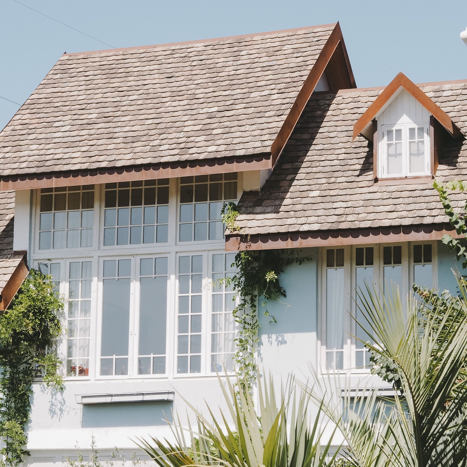 Light-colored home exterior with a large arrangement of bright divided-pane windows